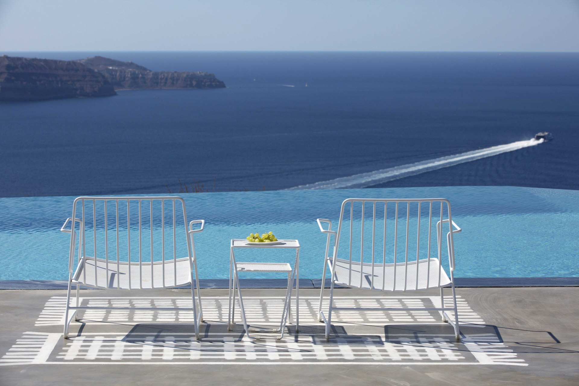 Sitzgelegenheiten am Pool mit Aussicht auf das Meer